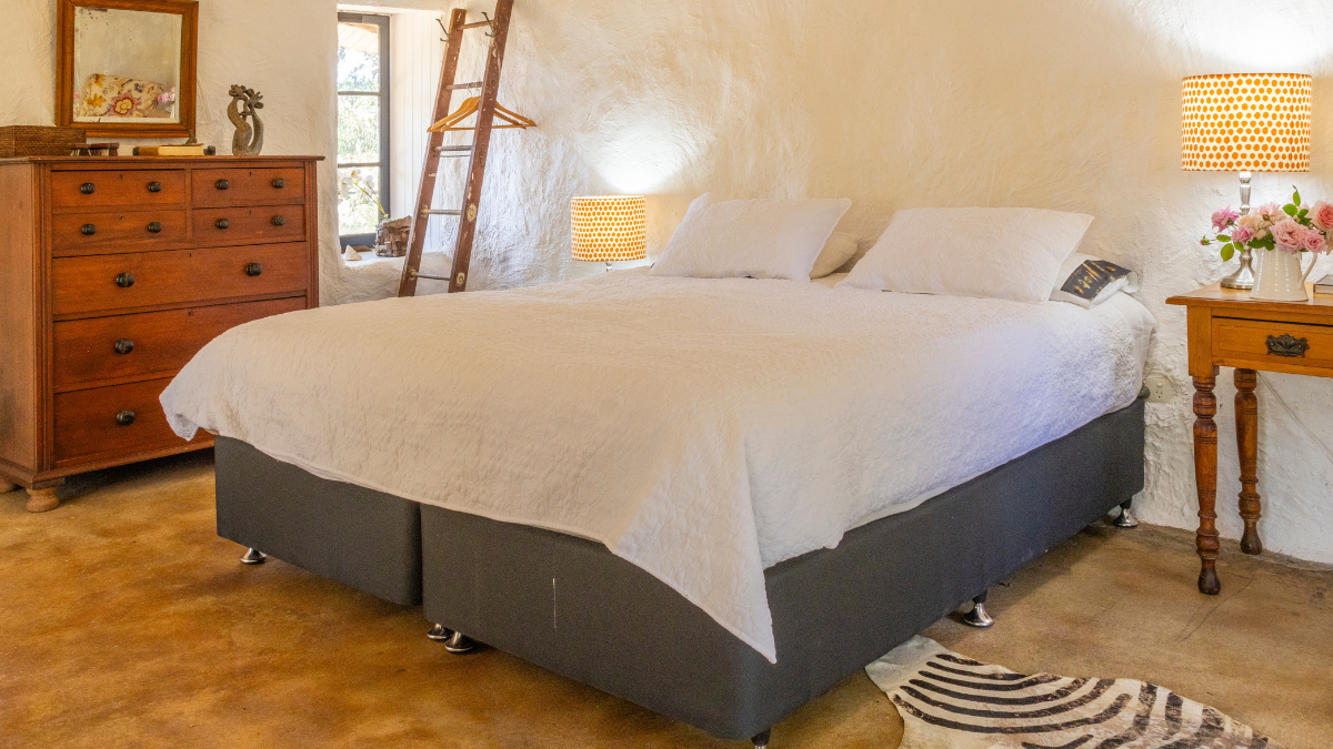 Bed in accommodation with wooden furniture around it 